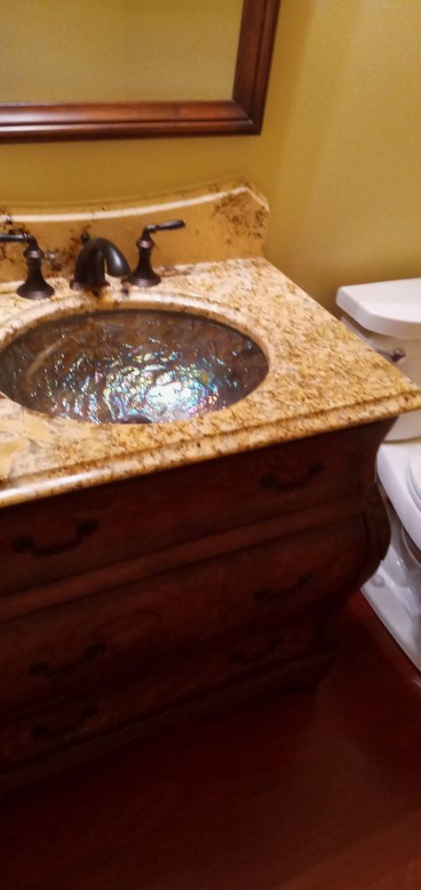 Bathroom vanity — warm wood cabinet, gold granite, vessel bowl sink